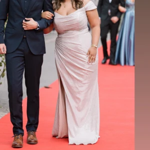 Glittrig champagnefärgad balklänning - Ska nu sälja min fina Balklänning ✨ Det en lång, glittrig balklänning från Dressroom Linné i champagnefärg. I storlek 16 motsvarar 44/46. Klänningen har offshoulder-ärmar, draperad överdel och en snygg slits framtill. Jag har inte anpassat klänningen så den är i original form som när jag köpte den OBS: Klänningen har en liten defekt som inte är särskilt synlig, men som kan ses vid närmare granskning. Kan visa Fler bilder om du är intresserad🥰Man får skyddet till klänningen vid köp               