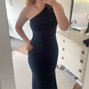 Marinblå one shoulder långklänning - Jätte fin marinblå långklänning! Aldrig använd! Jag är 1,70 cm lång och det är mina egna bilder, Hör gärna av dig om du undrar något, köp gärna med Instabox då jag postar snabbast där! Kvar tills markerad som såld 🫶🏼💘