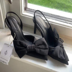 svarta klackar me rosett - svarta klackar med rosett. helt nya endast testade. dom var lite högre än va ja tänkte därför säljer ja dom då ja ej kan lämna tillbaka dom längre. klacken är 10 cm. nypris 399kr