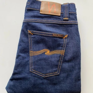 Mörkblå Nudie Jeans W29 L30 - Säljer ett par Nudie Jeans Lean Dean i mörkblå. De är sparsamt använda utan några skador eller slitage. Nypris: 1599 kr. Perfekta för dig som söker stiliga, hållbara och bekväma jeans. Hör gärna av dig om du har några frågor eller liknande🙌