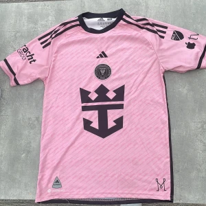 Inter Miami Messi 10 Adidas fotbollströja -  Pris kan duiskuteras som vanligt…… Säljer en rosa Inter Miami fotbollströja från Adidas med Messi 10 på ryggen. Tröjan har svarta detaljer, klubbmärke på bröstet och stora tryck på både fram- och baksida. Tillverkad i lätt och ventilerande material, perfekt för match eller träning.