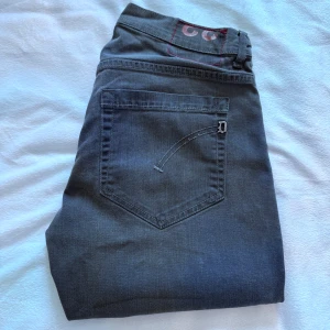 Grå  jeans från Dondup  - Snygga grå jeans från Dondup. Jeansen har klassiska fem fickor, silverfärgade nitar och en diskret logga på bakfickan. Materialet är mjukt och stretchigt för en bekväm passform. Midjemått: 40 cm benlängd: 104 cm !! Priset kan diskuteras!!