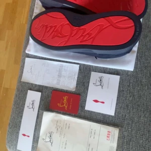 Christian Louboutin marinblåa sneakers storlek 44 - Snygga svarta sneakers från Christian Louboutin med ikonisk röd sula. Skorna har rund tå, snörning och är tillverkade i textil och skinn. Perfekta för dig som vill sticka ut med exklusiv design och streetkänsla. Skorna är i nytt skick använda en gång och är i storlek 44 kom dm ifall du har några funderingar.