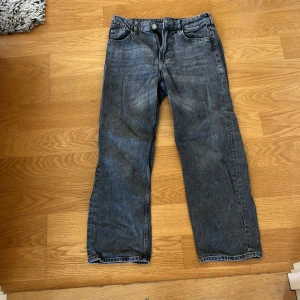 Grå loose fit jeans från H&M - Säljer ett par grå jeans från H&M i loose fit-modell med justerbar midja. Klassisk femficksdesign och raka ben. Perfekta för en avslappnad och trendig look. Passar dig som gillar bekväma och stilrena jeans.