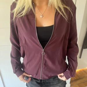 Vinröd bomberjacka - Snygg vinröd bomberjacka, helt oanvänd prislappen är fortfarande kvar !