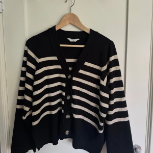 Svartvit randig kofta från Object - Randig kofta med knappar från Object - i toppskick! Använd cirka 5 gånger, känns som ny. Mjukt och behagligt material och funkar till både vardags eller för att klä upp lite extra! 