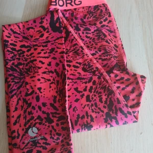 Björn Borg träningsleggings XS – unikt mönster! 🔥 - Supersnygga träningsleggings från Björn Borg, modell Wayan, i storlek XS. Iögonfallande neonrosa/orange mönster med svart leopardinspirerad design – perfekt för dig som vill sticka ut både på gymmet och till vardags.  ✅ Hydro-Pro™-material – andas och transporterar bort fukt ✅ Sköna, stretchiga och sitter perfekt ✅ Nypris ca 600 kr – säljes för 250 kr ✅ Mycket fint skick 