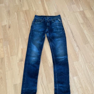 Mörkblå Replay jeans Wallys 14A - Snygga mörkblå jeans från Replay, modell Wallys. Klassisk femficksdesign med raka ben och diskreta slitningar framtill. Jeansen har normal passform och är tillverkade i slitstarkt denimtyg. Perfekta för dig som gillar en stilren och tidlös look.