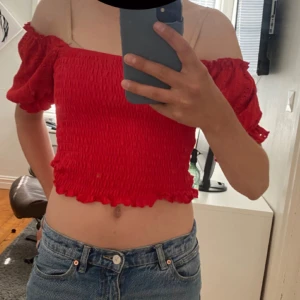 Röd offshoulder croppad topp - Säljer en röd  topp från Ustan Textiles med offshoulder och korta puffärmar. Perfekt till jul!