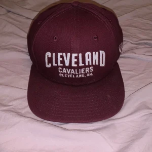 New Era Cleveland Cavaliers keps - Snygg vinröd snapback-keps från New Era 9Fifty med broderad Cleveland Cavaliers-logga framtill och klassisk platt skärm. Justerbar baktill och tillverkad i bomull. Perfekt för dig som gillar basket och streetwear.Aanvänd 2 gånger på sin höjd, annars bara samlat damm på hyllan. Har ni frågor eller vill ha mer bilder så är det bara att skriva. OBS FINNS UTE PÅ FLER SIDOR