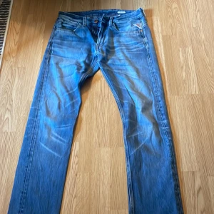 Blå Replay jeans straight fit 33/34 - Säljer ett par klassiska blå jeans från Replay i modell straight fit. Jeansen har fem fickor, snygga slitningar och kontrastsömmar. Perfekta för dig som gillar en tidlös look med lite edge. Midja och längd är 33/34.