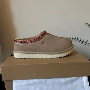 Beige UGG tasman  - UGG tasman i sand/beige färg, helt oanvända. Man kan både ha dom inomhus och utomhus.
