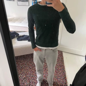 Mörkgrön stickad tröja Lindbergh - Snygg mörkgrön stickad tröja från Lindbergh med rund hals och diskret logga på bröstet. Tröjan har långärmade ärmar och en klassisk, normal passform som funkar till jeans eller chinos. Perfekt för dig som gillar stilrena och enkla plagg.