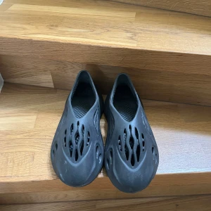 Svarta Yeezy Foam Runner - Svarta Yeezy Foam Runner som jag säljer eftersom de ej kommer till användning. De är använda max 10 gånger och anledningen till att de ser lite smutsiga ut är eftersom de stått väldigt länge och har inte fått för mig o tvätta de. Ingen box följer med!