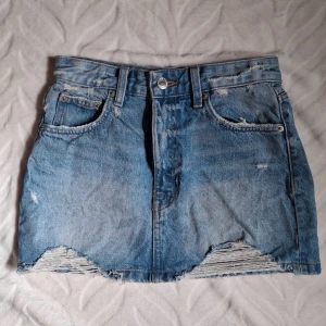 Blå jeanskjol från Pull&Bear XS - Säljer en blå jeanskjol från Pull&Bear i storlek XS. Kjolen har klassisk femficksdesign, slitna detaljer och rå kant nedtill. Passar till allt! Säljer då den inte kommer till användning, köpt på plick men aldrig använd, enbart prövad. Skriv för mått! 💕