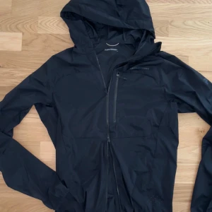 Peak Performance Vislight – svart vindjacka / wind jacket / windbreaker (M) - Peak Performance Vislight Wind Jacket, herrmodell i storlek M. Färg: svart. Dubbel dragkedja, mycket god andningsförmåga, reflexdetaljer och slitstarkt premium­material. Använd endast 1 gång – i princip nyskick. Nypris ca 1 900 kr (säljs i butik för runt 1 300 kr på rea). Perfekt för löpning, cykling, vandring eller vardagsbruk. Kan skickas eller hämtas på plats. Pris: 1 000 kr (bud beaktas)