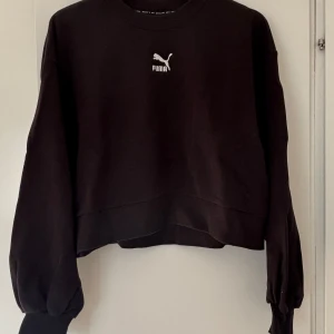 Svart sweatshirt från Puma - Säljer min sweatshirt från Puma i strl L. Ärmarna är muddade och modellen är rak och lite croppad. Perfekt om man vill ha en kortare sweatshirt utan att den ser ”för croppad” ut. Jag upplever den som lite liten i storleken🩷