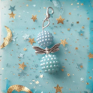 Blå smyckesängel/lyckoängel  - Unik ängel av två ljusblå pärlbollar och silverfärgade vingar i mitten. Hängsmycket har en praktisk karbinhake och ger en magisk vibe med sitt fantasifulla utseende. Perfekt för dig som gillar detaljer och drömmande stilar. Ängel är handgjorda av mig 