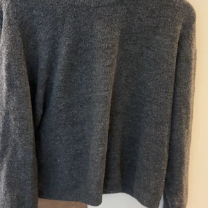 Mörkgrå stickad tröja från H&M - Mysig mörkgrå stickad tröja från H&M, använd ett fåtal gången, sann till storlek.