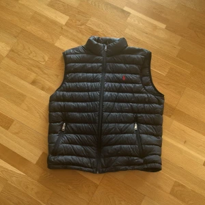 Ralph lauren Dunväst Svart - Svart Ralph lauren väst//säljer då den ej passar mig längre//sparsamt använd// pris kan diskuteras// skriv gärna vid intresse 