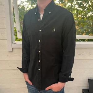 Svart Ralph lauren skjorta - Säljer jätte fin Ralph lauren skjorta, nypris är ungefär 1699kr, inga tecken på användning och väldigt bra skick, modelllen är slimfit, bara att skriva vid funderingar och den postas inom 48h👍