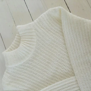 Vit stickad polotröja från H&M - Supermysig vit stickad polotröja från H&M i storlek XS. Tröjan har en hög, ribbad krage och långa ärmar med breda muddar. Perfekt för lager-på-lager och ger en clean och fräsch look till din outfit.