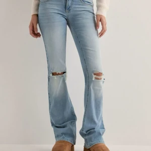Ljusblå bootcut jeans med slitningar - Jätte fina jeans från nelly, har tagit bort en del av bakfickorna. Säljer då dom är för små