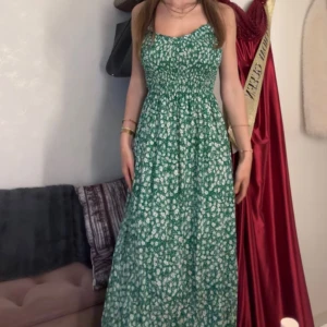 Grön blommig sommarklänning - Säljer en grön långklänning med vita blommor som är perfekt inför sommaren. Klänningen har justerbara axelband och sitter tajtare i midjan, så den framhävs. Den är från Missay i storlek S/M och är endast testad, alltså inte använd (prislapp finns kvar). Materialet känns lätt och luftigt, den är bekväm att bära. Vid fler frågor är det bara att höra av sig!💚