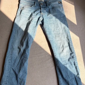 Replay Waitom ljusblå jeans - Säljer ett par ljusblå Replay Waitom jeans med klassisk femficksdesign och regular fit. Jeansen har raka ben och är tillverkade i mjukt denimtyg. Perfekta för dig som gillar en avslappnad och tidlös stil.