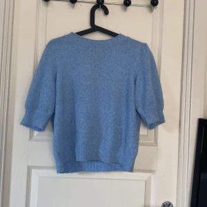 Ljusblå stickad tröja Vero Moda - Superfin ljusblå stickad tröja från Vero Moda i storlek M. Tröjan har kortare puffärmar och ribbade muddar vid ärmslut och nederkant. Perfekt för dig som gillar en mjuk och mysig look med lite volym i ärmarna.