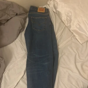 Levi's Stay Loose blå jeans - Säljer ett par Levi's Stay Loose jeans i klassisk blå denim. Jeansen har fem fickor, gylf med dragkedja och knapp, samt den ikoniska Levi's-lappen bak. Modellen är loose fit med raka ben och tydliga kontrastsömmar.