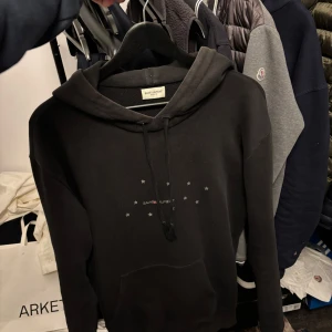 Saint Laurent hoodie - Säljer en exktremt snygg saint Laurent hoodie i storlek s, slim fit, självklart autentiskt, har en defekt, men syns inte vid användning, pris kan diskuteras vid snabb affär Sicka gärna pris förlag, ny pris ca 10000kr