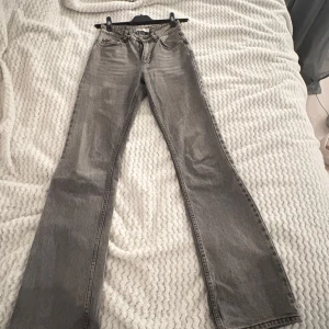Gråa bootcut jeans från Gina Tricot - Säljer ett par gråa jeans från Gina Tricot mid waist med bootcut Ben och Jeansen har mid waist på mig är dem precis under naveln och går ner till golvet på mig som är 168 säg till om du vill ha bild på dem på eller har du frågor eller funderingar så är de bara i skriva hoppas vi hörs köparen står för frakten 