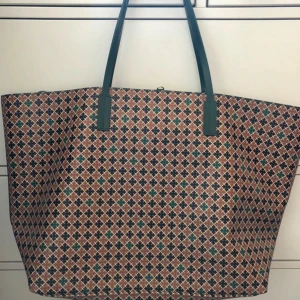 Malin Berger-väska - Beskrivning  Malin Berger-väska, i utmärkt skick. Använd flera gånger, som ny. Höjd: 30 cm  Längd: 46 cm  Bredd: 14 cm  Handtag: 21