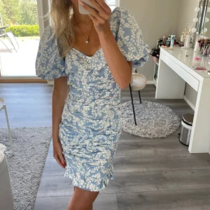 Blåvit blommig kortklänning med puffärm - Super fin blå blommig klänning, jag har använt en gång och en tidigare har använt en gång, inget fel på klänningen, den är lite stor på mig därför återanvänder jag tidigare tjejens bild!💗