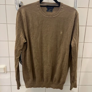 Beige merinoulltröja Polo Ralph Lauren - Slim fit beige tröja från Polo Ralph Lauren i mjuk merinoull. Klassisk rund halsringning och diskret broderad logga på bröstet. Har ett riv på armen därav säljer jag den billigt. Storlek M men skulle föredra för S. | Pris 149kr |