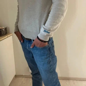 Svart pärlarmband med detaljer - Stilrent svart armband med runda pärlor och några metallfärgade detaljer i mitten. Armbandet har en enkel och modern design som passar till det mesta. Levereras i snygg ask.