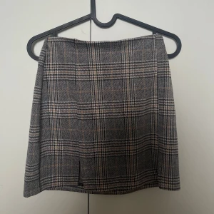 Rutig kortkjol från HM XS - Superfin rutig kortkjol från HM i grått, svart och beige med små slitsar framtill. 