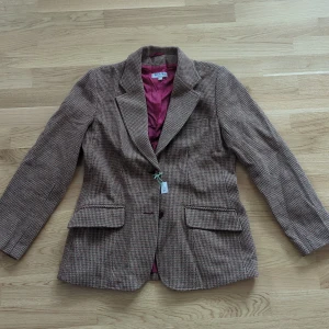 Brun vintage kavaj - Jättefin brun kavaj med rött foder. Den är lite varmare i färgen i verkligheten än vad bilderna visar. Fint skick 