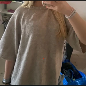 Trekvartsärmad Beige stickad tröja - Mysig beige stickad tröja med breda, lite kortare ärmar och rund halsringning. Tröjan har en loose fit och är perfekt att slänga på sig när det är kyligt. Enkel och stilren design som funkar till allt.