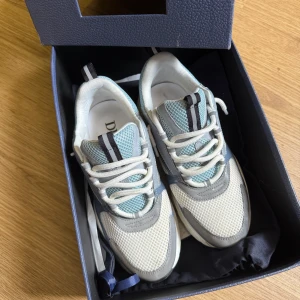 Dior b22 skor - Snygga Dior sneakers i vitt, ljusblått och grått med mesh och skinnpaneler. Kvitto finns kvar skriv gärna om ni är intresserad 