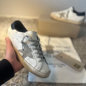 Golden goose - Tja! Säljer nu dessa sjukt snygga och eftertrakde Golden goose superstar i riktigt bra skick|| Skick: 8/10|| Storlek: 41|| Nypris: ~6000kr Mitt pris: 2900 men priset kan diskuteras|| Vad ingår: Dustbag, Box, kort och lite mer|| Om ni har frågor eller funderingar är det bara att fråga|| Mvh Oscar