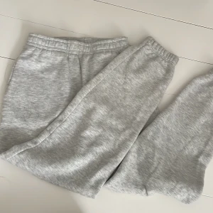 Grå mjukisbyxor från Gina Tricot  - Superbekväma ljusgrå mjukisbyxor från Gina Tricot, basically basics-kollektionen. Tillverkade i mjuk bomullsmix med resår i midjan och sidofickor. Har blivit smått nopprig på några ställen. Mjuk och len på insidan