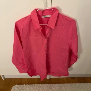Rosa skjorta från LCW Casual, stl S - En snygg rosa skjorta från LCW Casual i storlek S. Skjortan har klassisk krage, knäppning framtill och långa ärmar. Perfekt för dig som vill ha en färgstark och enkel skjorta i garderoben.