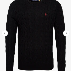 Svart stickad tröja från Ralph Lauren - Snygg svart stickad tröja från Ralph Lauren med kabelstickat mönster och det ikoniska röda logotypbroderiet på bröstet. Tröjan har långa ärmar och en rund halsringning. Perfekt för kyligare dagar! Ny pris 1500kr. PRISET GÅR ATT DISKUTERA