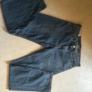 Blå jeansbyxor - Säljer ett par klassiska blå jeansbyxor med normal passform då de inte används. De har en traditionell femficksdesign och är tillverkade i slitstarkt denim. Perfekta för en avslappnad stil. Relaxed fit 