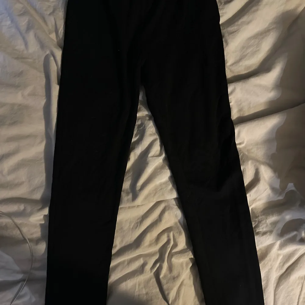 Snygga svarta mjukis byxor från Calvin Klein med elastisk midja och diskret logga. Perfekta för en stilren och bekväm look.. Farkut & Housut.