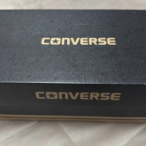 Svarta Converse All Star sneakers - Helt nya Klassiska svarta Converse All Star sneakers med vit sula och snörning. Perfekta för en avslappnad stil. 