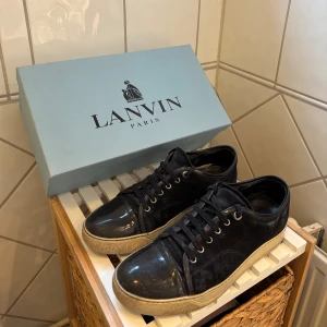 Mörkblå sneakers från Lanvin - Lanvin Cap Toe mörkblå i bra skick. Skorna är i bra skick men skulle behöva rengöras lite och det finns tecken på användning som på bild 4 och 5 Storlek 7 i UK och passar 42-43. Box medföljer. Skriv om du har frågor!