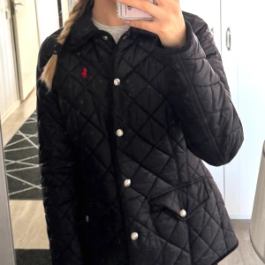 Polo Ralph Lauren jacka  - Säljer denna svarta quiltad jacka från Polo Ralph Lauren. Köptes i nu i oktober och har knappt använts så den är som ny. Köpte den från Nelly för 4299 kr.